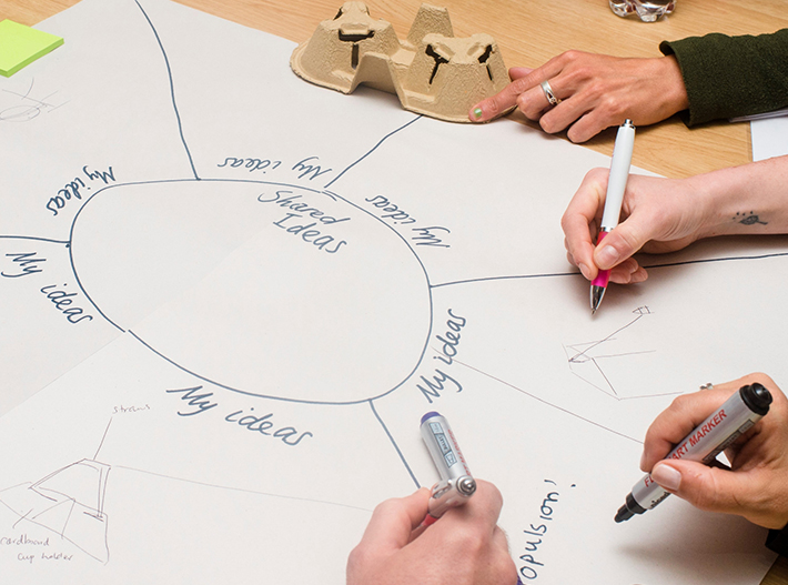 Four hands writing on paper