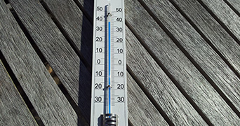 Thermometer pictured against wooden slabs
