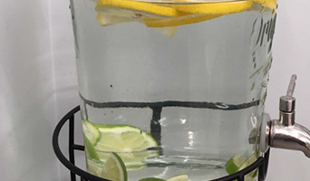 Water jug with chopped up lemons and limes in