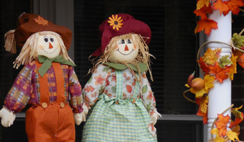 Toy scarecrows holding hands