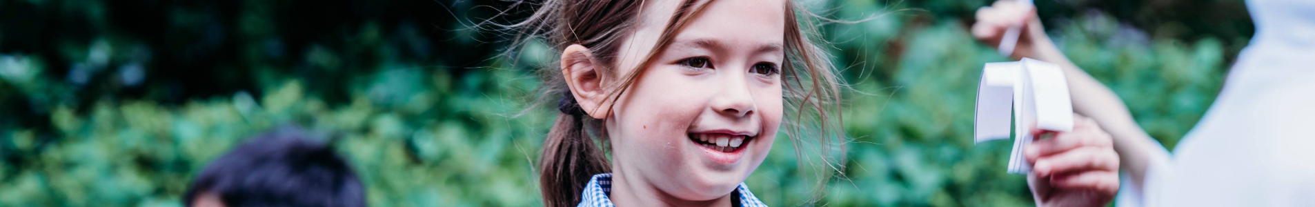 a primary child testing their paper spinner outside