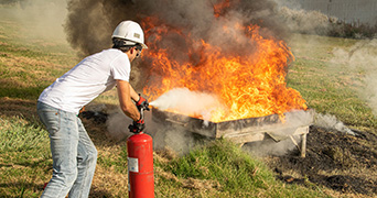 Man extinguishing fire with a fire extinguisher