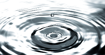 an close image of a water droplet and water ripples