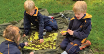 JES issue 21 cover of three primary children engaged in outdoor learning