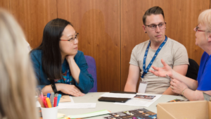 three people taking part in a group discussion during a primary science professional development session